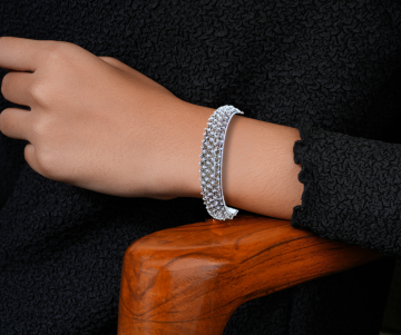 Zilveren granulatie cannetille armband op arm hout stoel