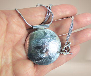 Zilveren ketting grote amulet hanger chinees innerlijke vrede teken beige achtergrond