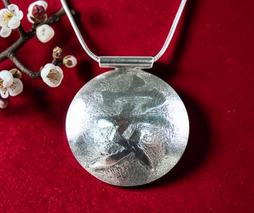 Zilveren ketting grote amulet hanger chinees innerlijke vrede teken rode achtergrond