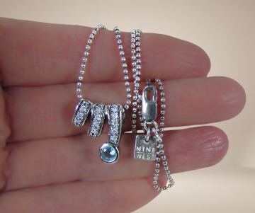 Zilveren nieuwe hanger zirkonia blauw accent nine west ketting beige achtergrond 3