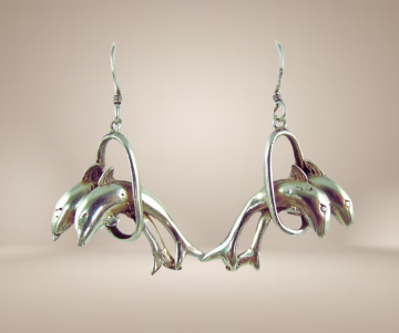 Zilveren oorbellen  dolfijnen door hoepel beige achtergrond 1