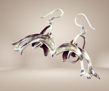 Zilveren oorbellen  dolfijnen door hoepel beige achtergrond 4