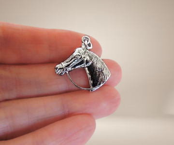 Zilveren paarden bedel beige achtergrond