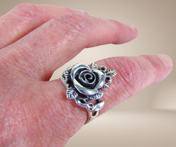 Zilveren roos ring met blaadjes beige achtergrond