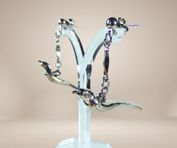 Zilverkleur vogel oorbellen beige achtergrond