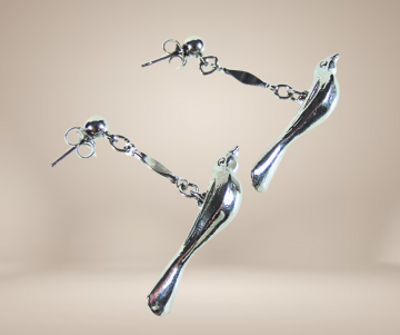 Zilverkleur vogel oorbellen beige achtergrond 1