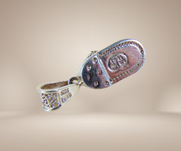 Zware mexico zilveren meisjesschoen hanger beige achtergrond