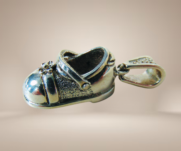 Zware mexico zilveren meisjesschoen hanger beige achtergrond 3