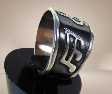 Zwart zilveren brede muzieknoten ring beige achtergrond