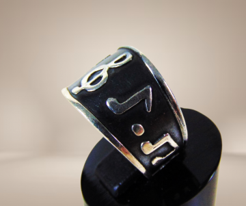 Zwart zilveren brede muzieknoten ring beige achtergrond 1