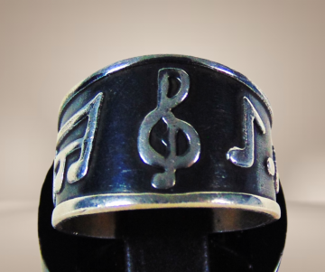 Zwart zilveren brede muzieknoten ring beige achtergrond 2