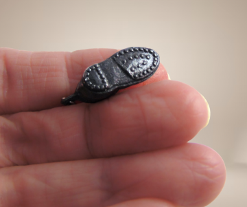 Zwarte schoenen oorbellen beige achtergrond 1